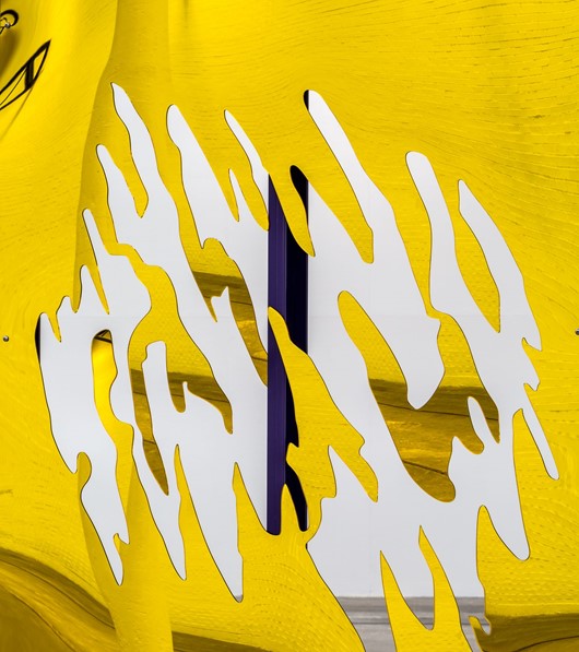 A close up of a yellow 2-D sculpture