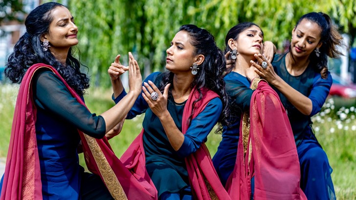 For dancers in saris strike playfully dramatic poses