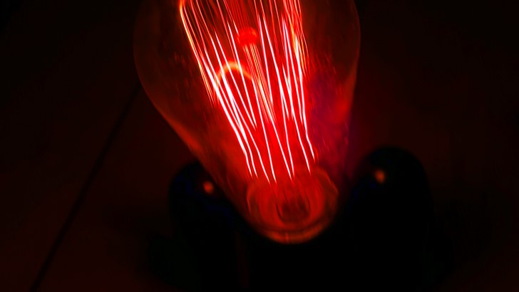 A red LED light bulb glows in the dark