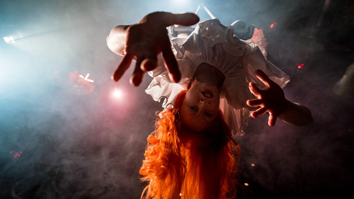Performer Vee Smith pictured from below, hanging upside down 