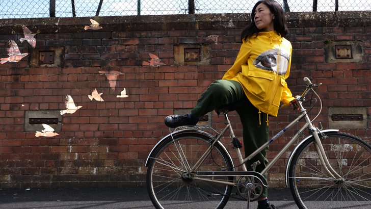 Dancer Aya Kobayishi is pictured with a bike against an urban backdrop