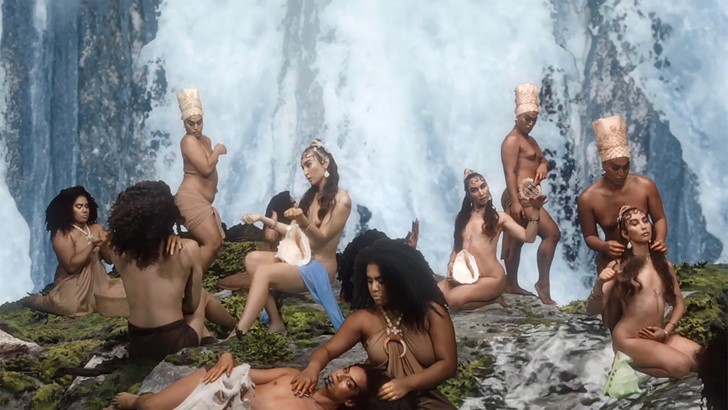An idyllic tableau of figures in different poses in front of a waterfall