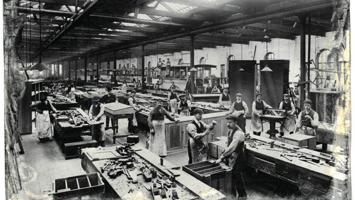 An archive photo depicts a busy factory floor in the early 20th century