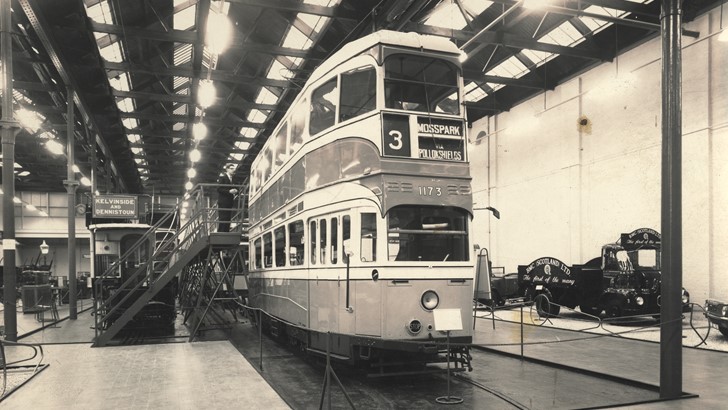 An archive photo depicts a tram displayed in an old museum gallery